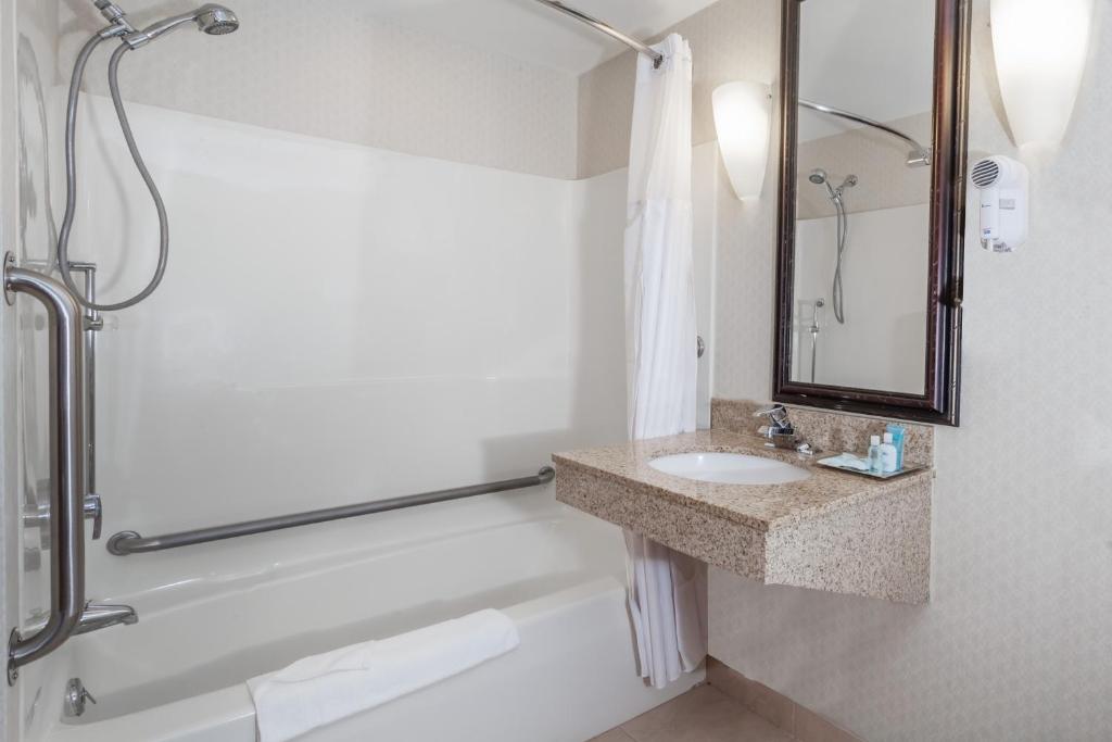a bathroom with a tub and a sink and a shower at Wyndham Southbury in Southbury