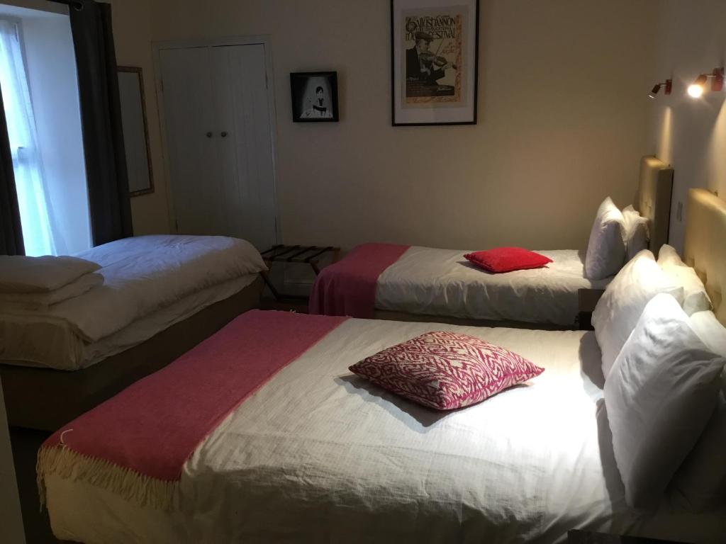 a hotel room with two beds and a window at Rolling Wave Guesthouse in Bundoran