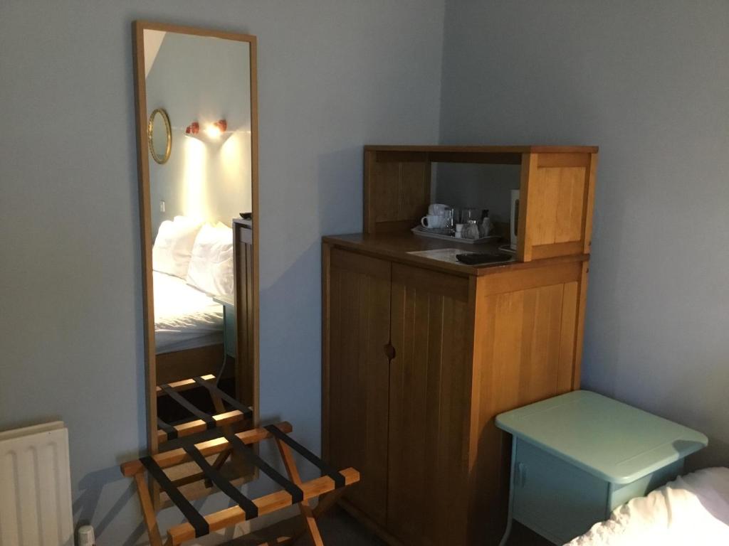 a room with a mirror and a bed and a vanity at Rolling Wave Guesthouse in Bundoran
