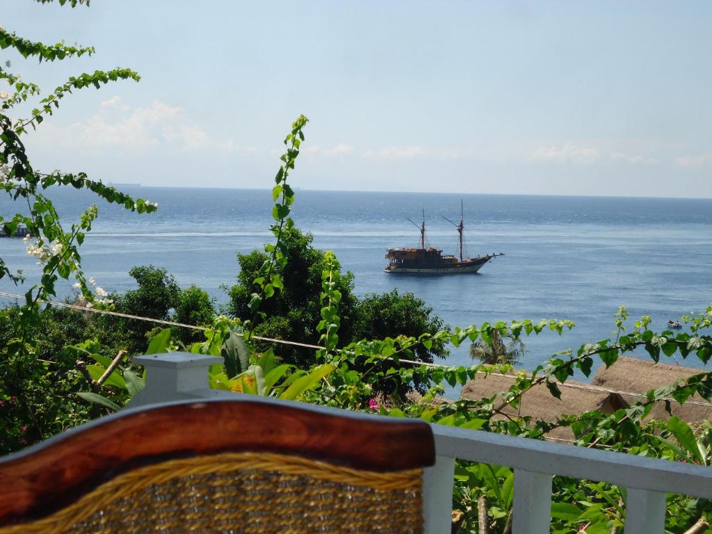 un bateau dans l'océan avec un balcon dans l'établissement Baliku Dive Resort, à Amed