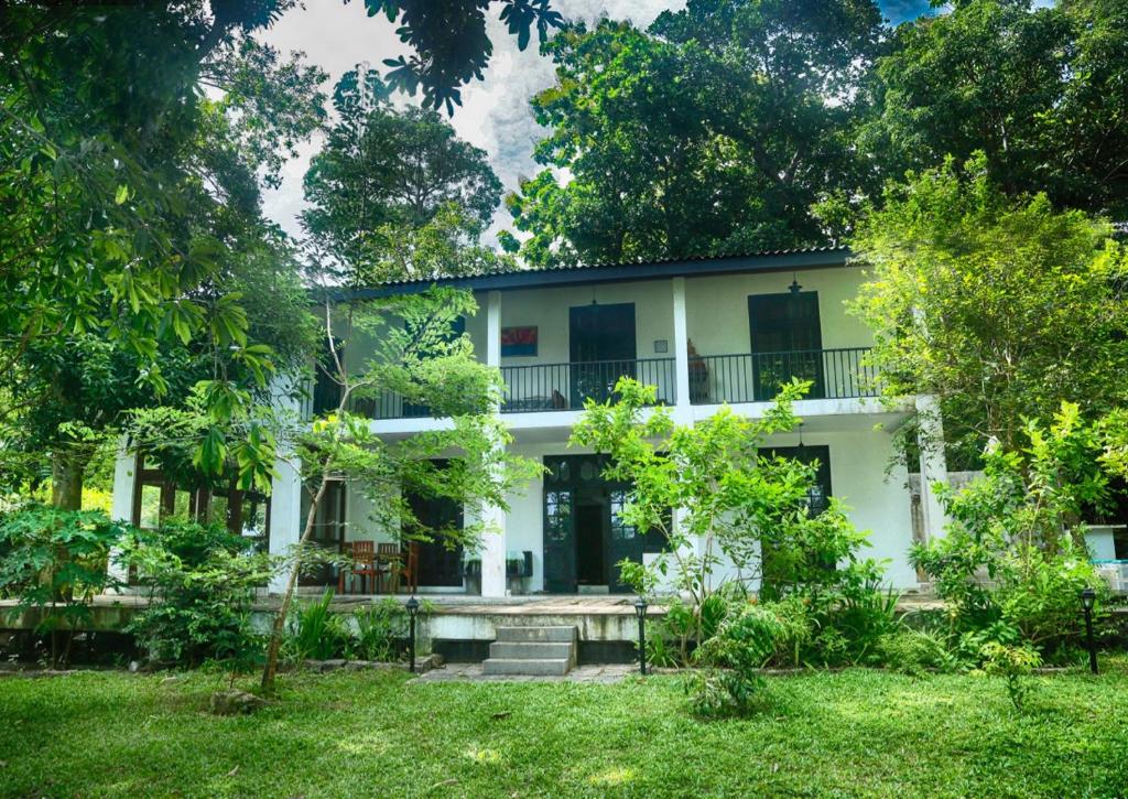 - une vue sur l'extérieur d'une maison blanche avec des arbres dans l'établissement Villa by the Lake Bolgoda, Moratuwa-Colombo, à Moratuwa