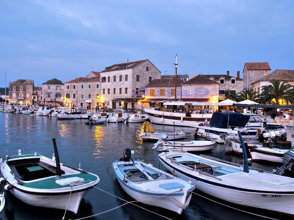 a group of boats docked in a harbor with buildings at House at the seafront in Stari Grad