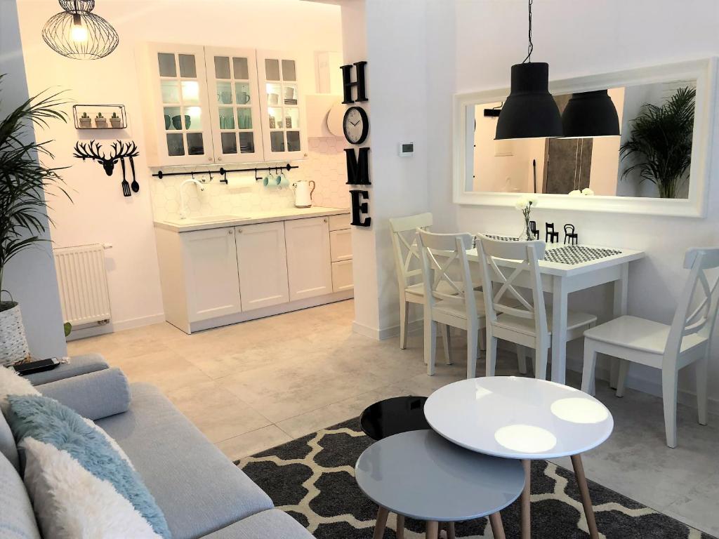 een woonkamer en een keuken met een bank en een tafel bij Apartament BellaPola 2 in Nysa