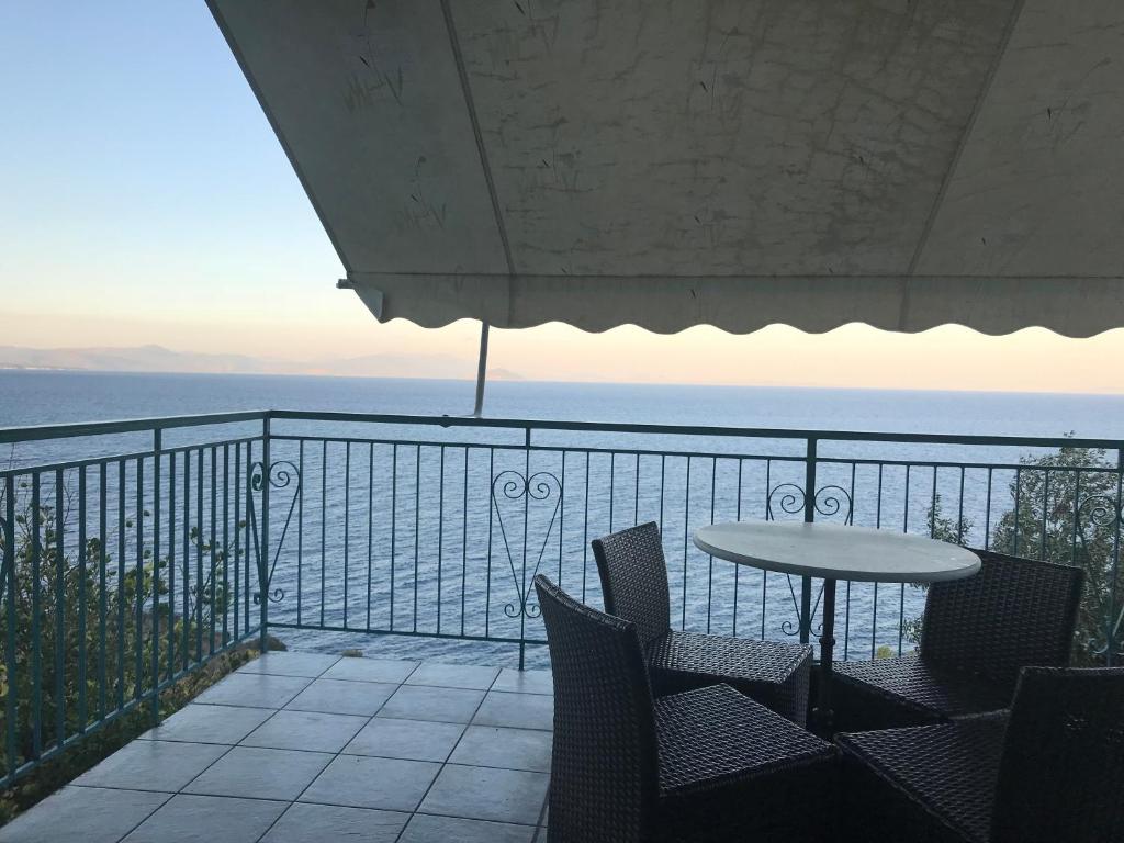 パラリオ・アストロスにあるVilla Castle Sea Viewの海を望むバルコニー(テーブル、椅子付)