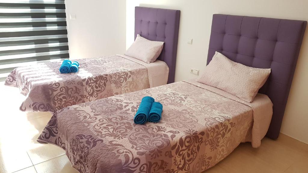コティージョにあるExclusiva Vivienda en Cotilloのベッドルームに青いスリッパ付きのベッド2台