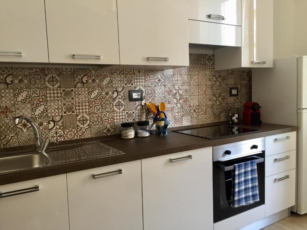 a kitchen with white cabinets and a sink at Casa Matuzia in Sanremo