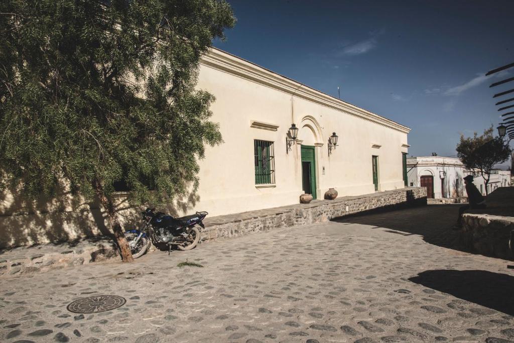 ein Motorrad, das vor einem weißen Gebäude parkt in der Unterkunft Casa del Tejedor in Cachí