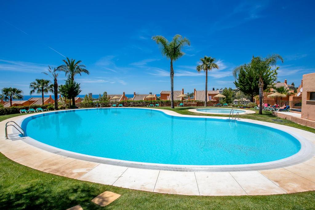 una gran piscina en un patio con palmeras en R16 Jans penthouse with amazing views en Marbella