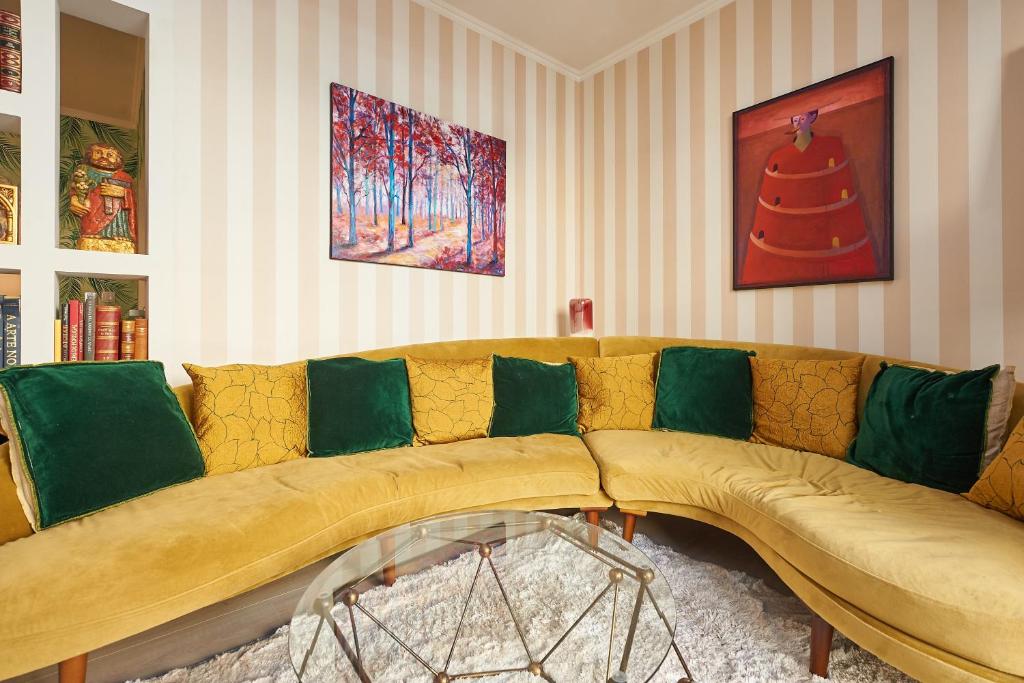 salon z żółtą kanapą z zielonymi poduszkami w obiekcie Luxurious triplex near the beach In Estoril w mieście Estoril