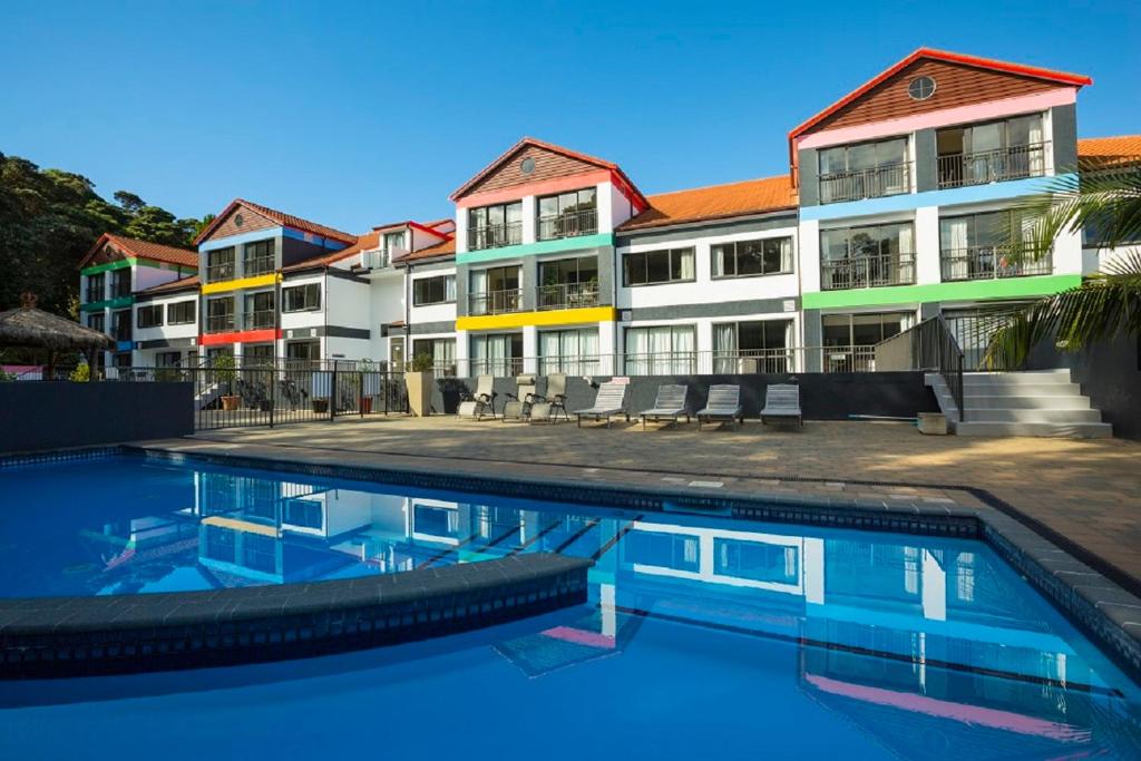 a building with a swimming pool in front of a building at Quality Hotel Oceans Tutukaka in Tutukaka