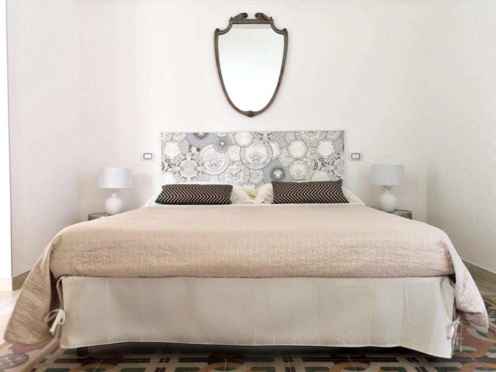 um quarto com uma cama grande e um espelho na parede em Eccelsoleccese em Lecce