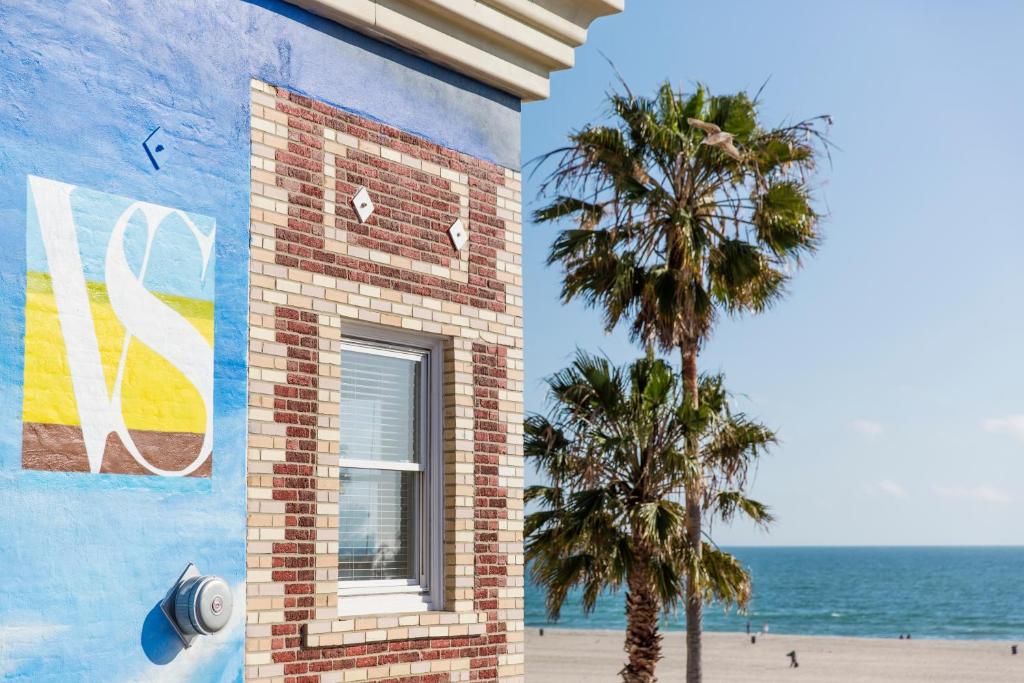a building with a palm tree next to the beach at Venice Suites in Los Angeles