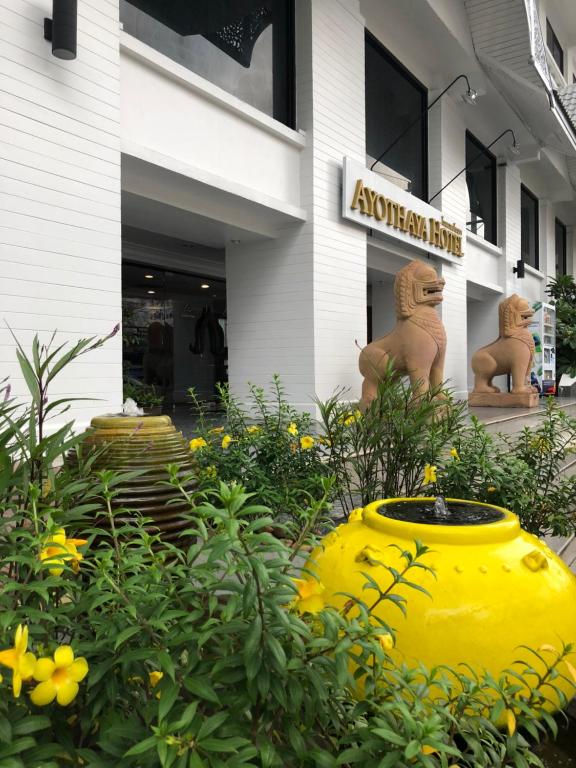 a large yellow vase in front of a building at Ayothaya Hotel in Phra Nakhon Si Ayutthaya