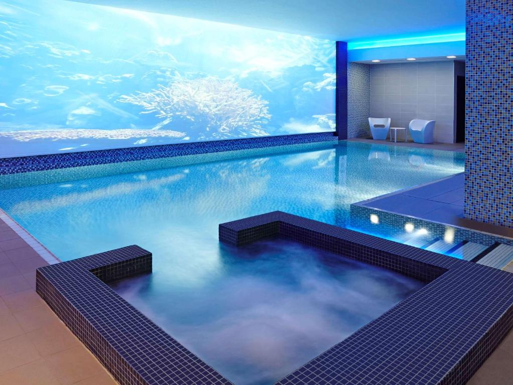 a swimming pool with an aquarium in a hotel room at Novotel London Blackfriars in London