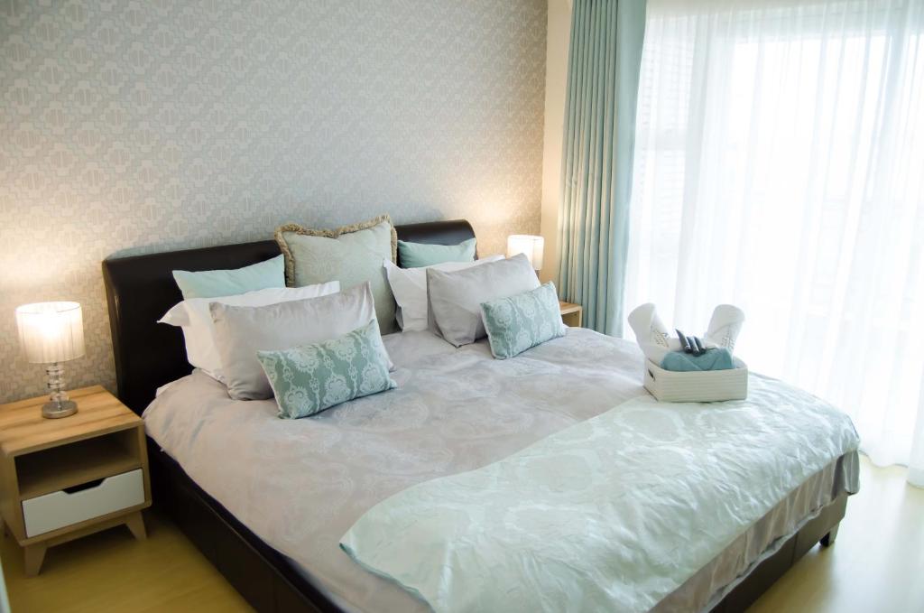 1 dormitorio con 1 cama grande con almohadas blancas y azules en Aya Luxury Apartments 56, en Durban