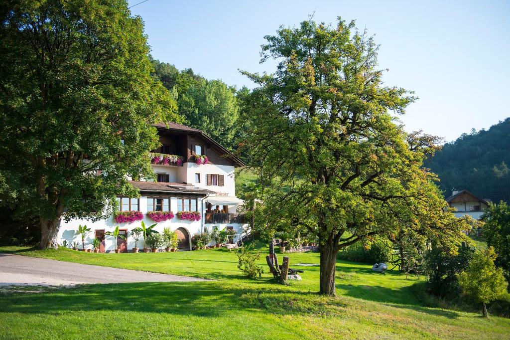 a large white house with trees in front of it at Gasthof Wieser in Appiano sulla Strada del Vino