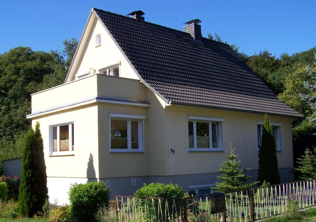 ein weißes Haus mit einem schwarzen Dach in der Unterkunft FerienWohnung Gebhardt in Binz
