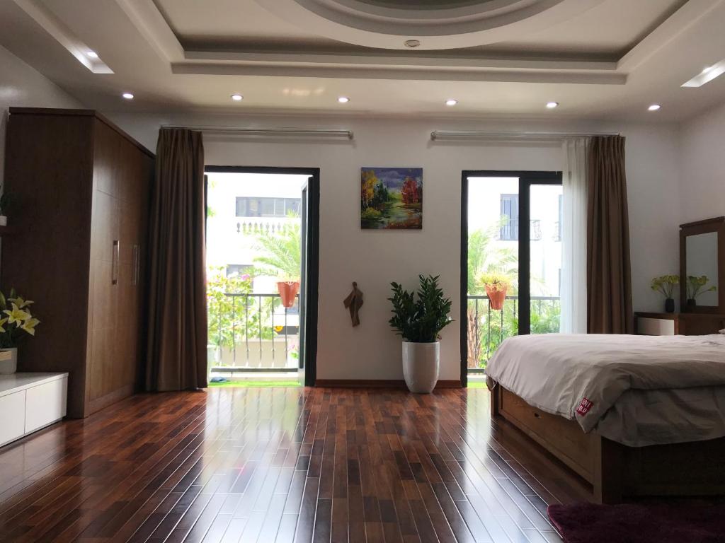 sypialnia z łóżkiem i przesuwnymi szklanymi drzwiami w obiekcie Lea House Ha Long w Ha Long