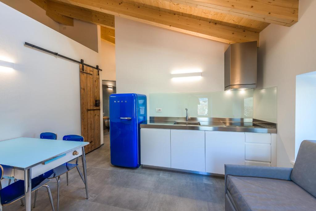 a kitchen with a blue refrigerator and a table at Casa Kaki in Malcesine