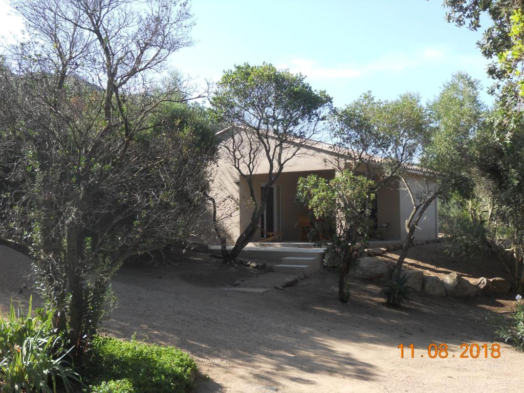 una casa con árboles delante de ella en hébergement figari en Figari