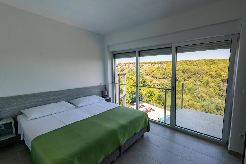 a bedroom with a bed and a large window at Premantura Resort - Hotel & Restaurant in Premantura