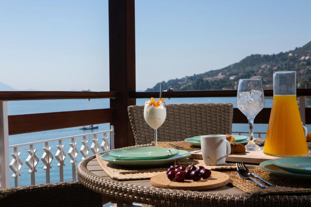 einen Tisch mit Speisen und Getränken auf dem Balkon in der Unterkunft Arokaria Beach House in Nikiana