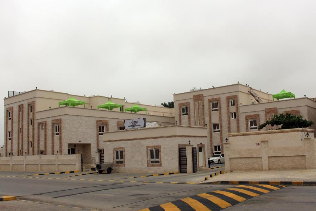 ein großes Gebäude mit einem Parkplatz davor in der Unterkunft Al Noor Plaza in Salalah