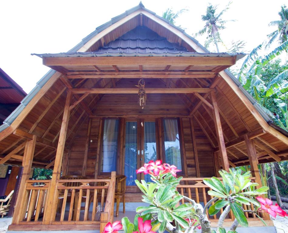 a wooden house with a large glass door at Nusa Penida Pudak Nature Bungalow in Nusa Penida
