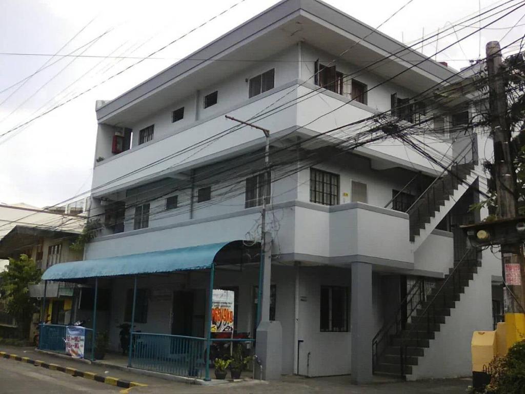a large white building with a staircase in front of it at JS3 Studio Apartments in Legazpi