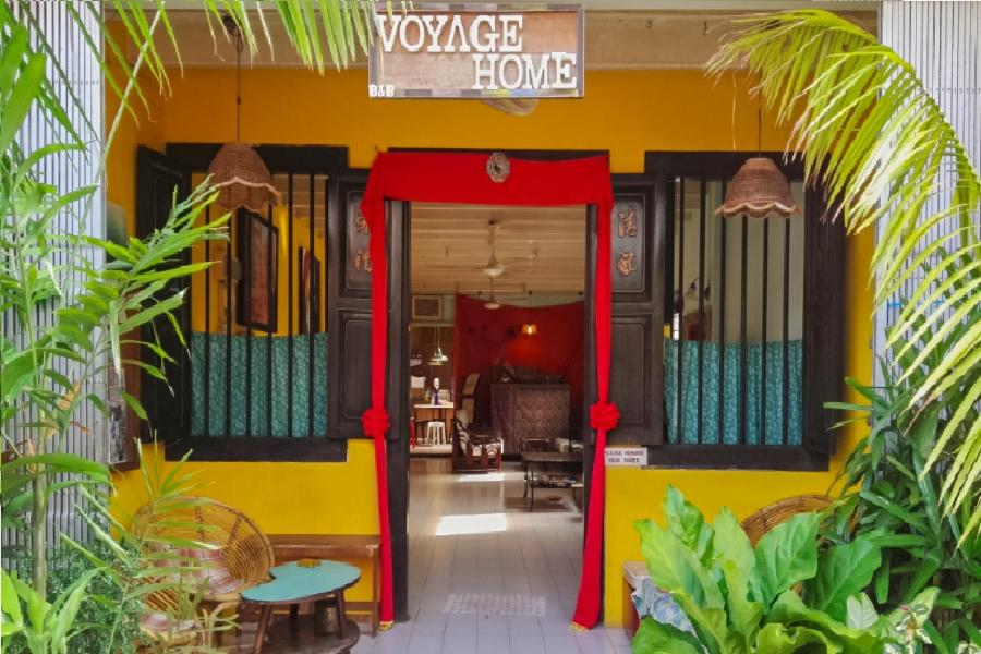 una casa gialla e rossa con una porta rossa di Voyage Home&Guesthouse a Malacca