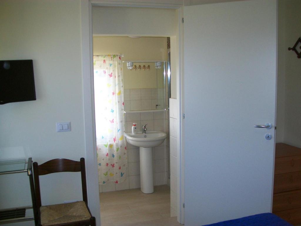 un bagno con lavandino, water e specchio di Affittacamere il girasole a Recanati