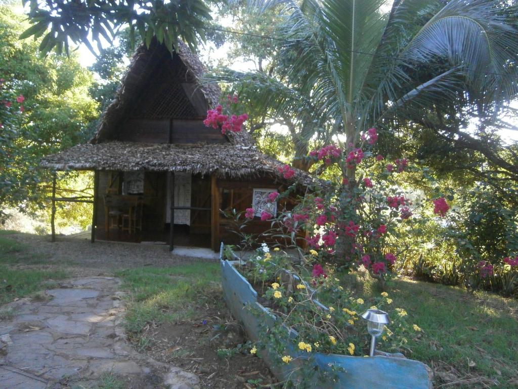 a small house with flowers in front of it at LES CHALETS DE MELINDA in Nosy Be
