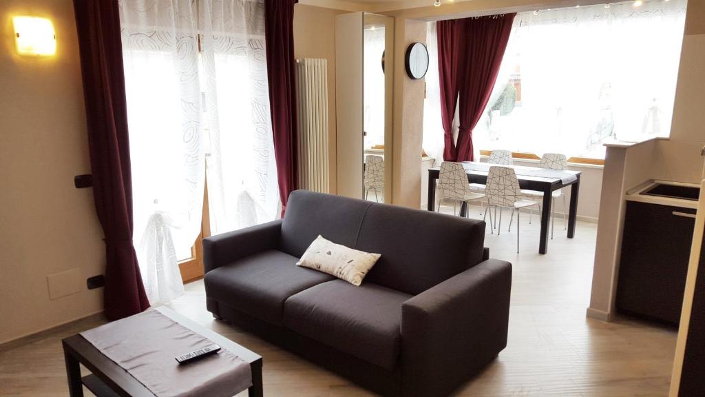 uma sala de estar com um sofá e uma mesa em Palmira Guest House em Aosta
