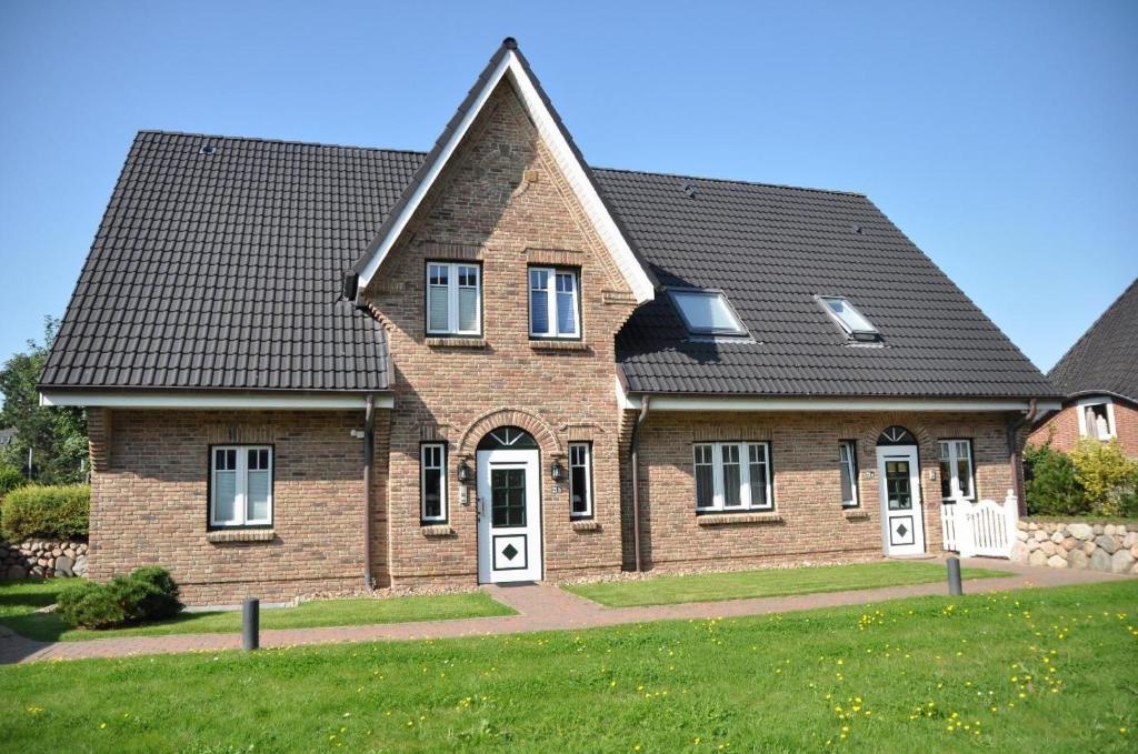 ein Backsteinhaus mit schwarzem Dach in der Unterkunft Appartement christ-sylt in Westerland