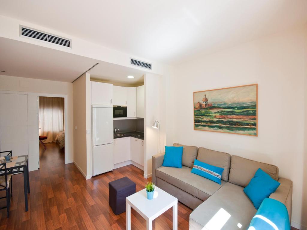 Apartamentos Murallas de Sevilla في إشبيلية: غرفة معيشة مع أريكة وطاولة