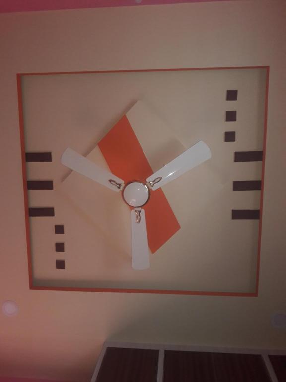 a clock with a fan on a wall at Rks Homestay in Hampi