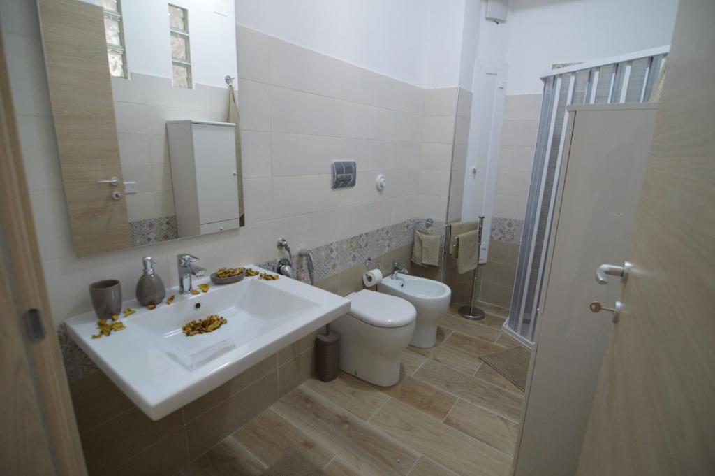 łazienka z białą umywalką i toaletą w obiekcie Triscele Casa Vacanze w mieście Portopalo