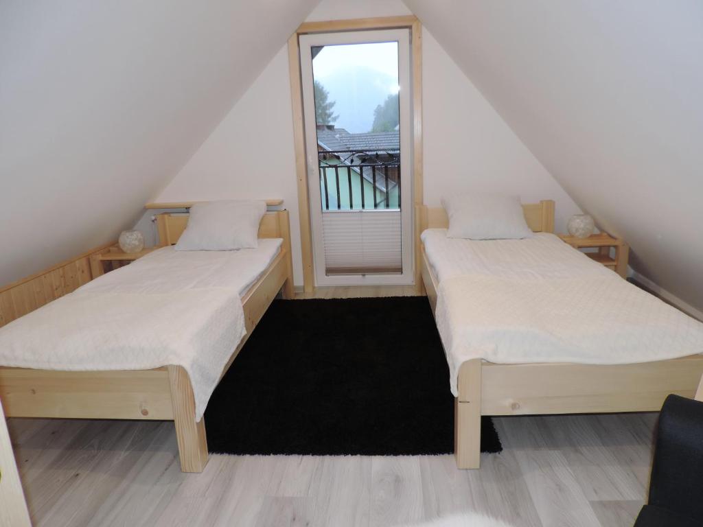 two beds in a room with a window at Na Świerkowym Strychu in Szczawnica