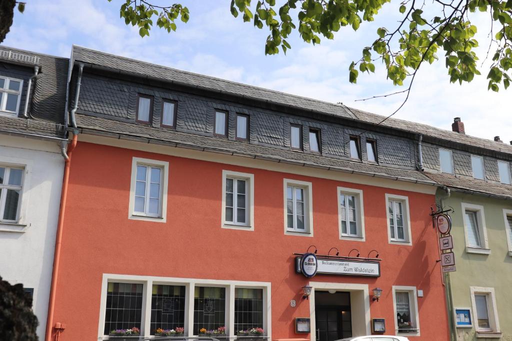 um edifício vermelho com um telhado preto em Hotel Zum Waldstein em Weißenstadt