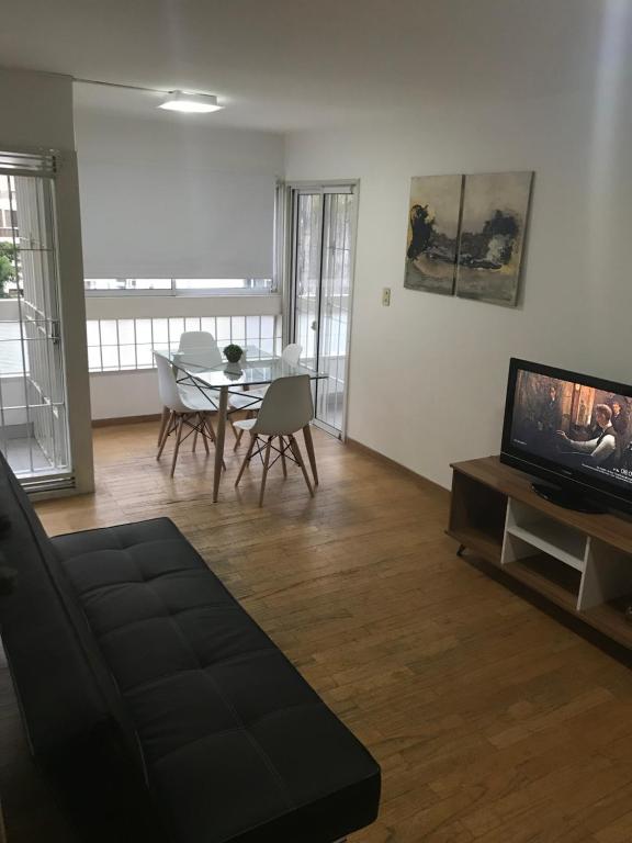 sala de estar con sofá, TV y mesa en Torre Augusta en Córdoba
