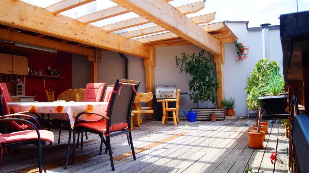 un patio con mesa, sillas y techo de madera. en Ferienwohnungen Dzido, en Hermagor