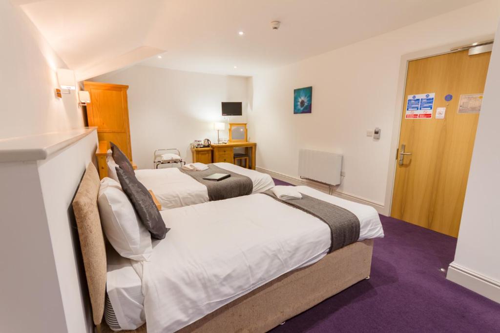a hotel room with two beds and a door at Gwesty Seren Hotel in Blaenau-Ffestiniog