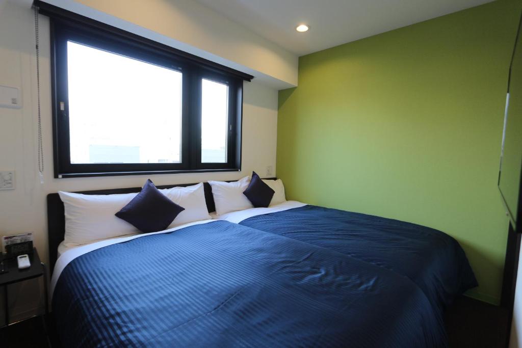 Postel nebo postele na pokoji v ubytování HOTEL LiVEMAX Ueno-Ekimae