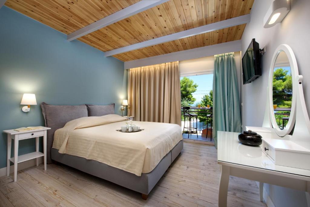 a bedroom with a large bed and a balcony at La Soffitta in Benitses