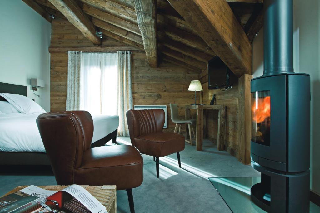 a room with a fireplace and a bed and a room with a bed at Chalet-Hôtel La Marmotte, La Tapiaz & SPA, The Originals Relais in Les Gets