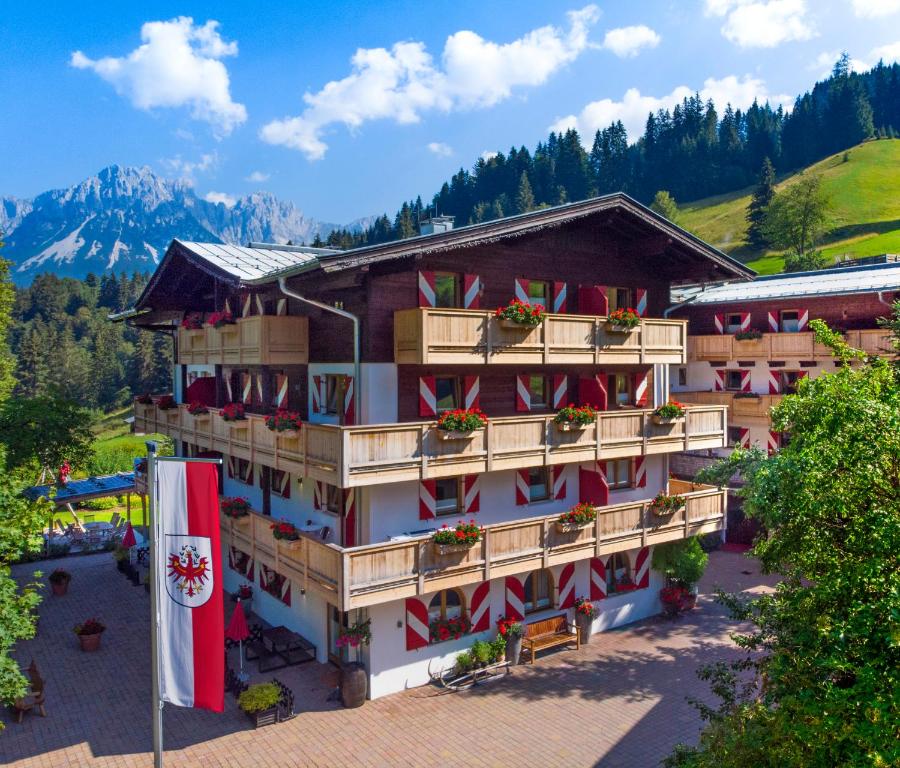 ein Hotel mit einer Flagge davor in der Unterkunft Ferienappartements Landhof in Ellmau