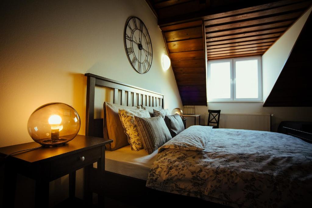 a bedroom with a bed and a clock on the wall at Sobe "Majerling" in Majerje