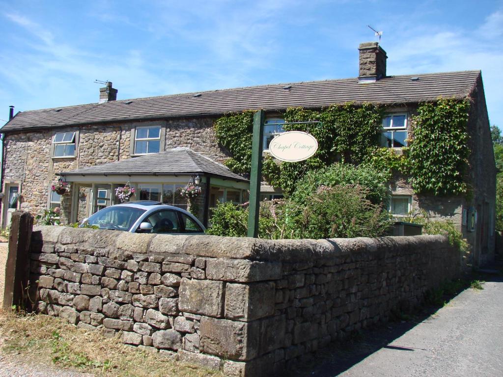 a house with a stone wall in front of it at Chapel Cottage Clitheroe Road in Waddington