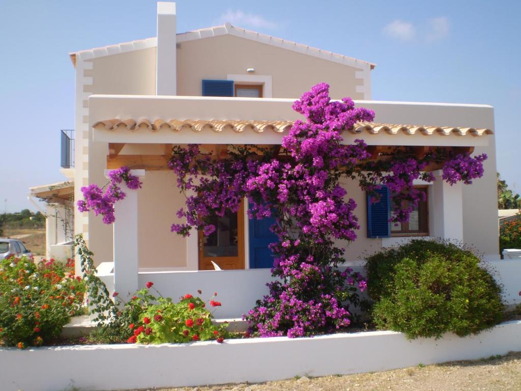 a house with purple flowers in front of it at Casa Rural Ideal para Parejas - Formentera in Sant Francesc Xavier