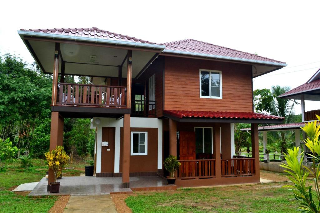 ein Haus mit einem Balkon und einer Veranda in der Unterkunft Bang Hon Homestay in Ko Yao Noi